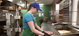 Tyttö valmistamassa pizzaa
